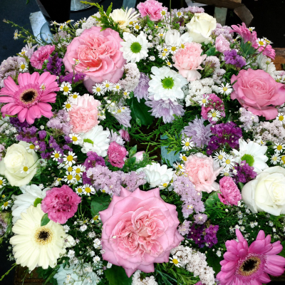 Pretty in Pink Wreath - A pink Wreath to include Pink Roses ans Cream Roses Gerberas, Carnations and Daisies with a mix of seasonal foliage and filler flowers  Standard Size is on a 14 inch Oasis Ring