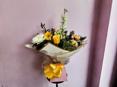 Golden Sunshine - A cheerful and uplifting arrangement featuring a beautiful palette of sunny yellow, crisp white and soft pastel tones, enhanced with rich greenery and interesting textures. Elegantly presented in gold-edged wrapping with a bright yellow bow, this joyful design is perfect for birthdays, thank-you wishes, congratulations or simply sending a little sunshine.