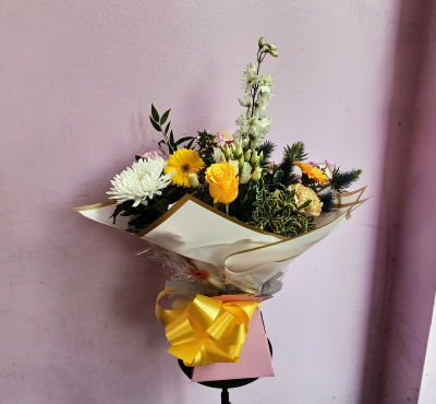 Golden Sunshine - A cheerful and uplifting arrangement featuring a beautiful palette of sunny yellow, crisp white and soft pastel tones, enhanced with rich greenery and interesting textures. Elegantly presented in gold-edged wrapping with a bright yellow bow, this joyful design is perfect for birthdays, thank-you wishes, congratulations or simply sending a little sunshine.