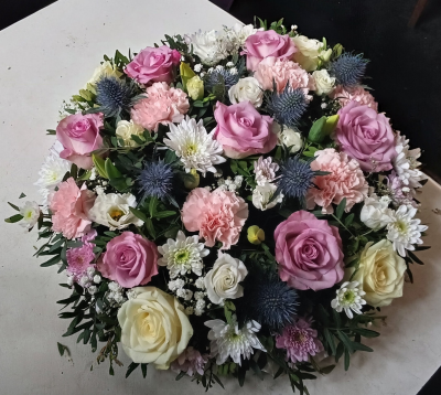 Blushing Serenity Posy - A beautifully rounded posy arrangement in soft blush pink, gentle lilac, creamy white and delicate blue tones. Thoughtfully designed with lush greenery and a graceful, balanced finish, this elegant tribute conveys love, tenderness and peaceful remembrance. A heartfelt choice for honouring someone truly special.